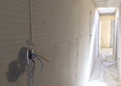 wires poking out the wall in the hallway
