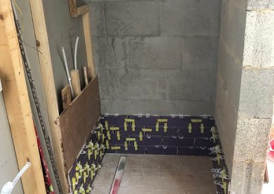 Tiling around the shower area with frame for waterfall shower installed