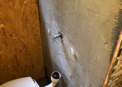 Toilet area before - rough render and wood panelling